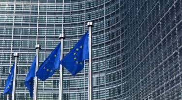 EU flags in front of the European Commission building in Brussels