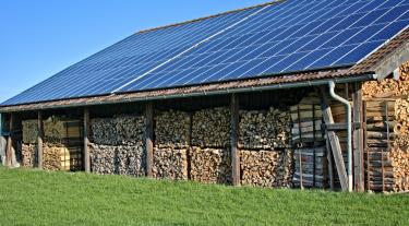 solar panels on roof of large wood shed