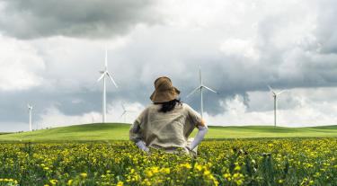 Person in field with wind turbine