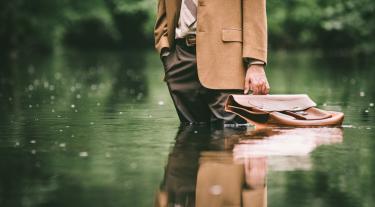 business man with a briefcase standing up to his knees in water